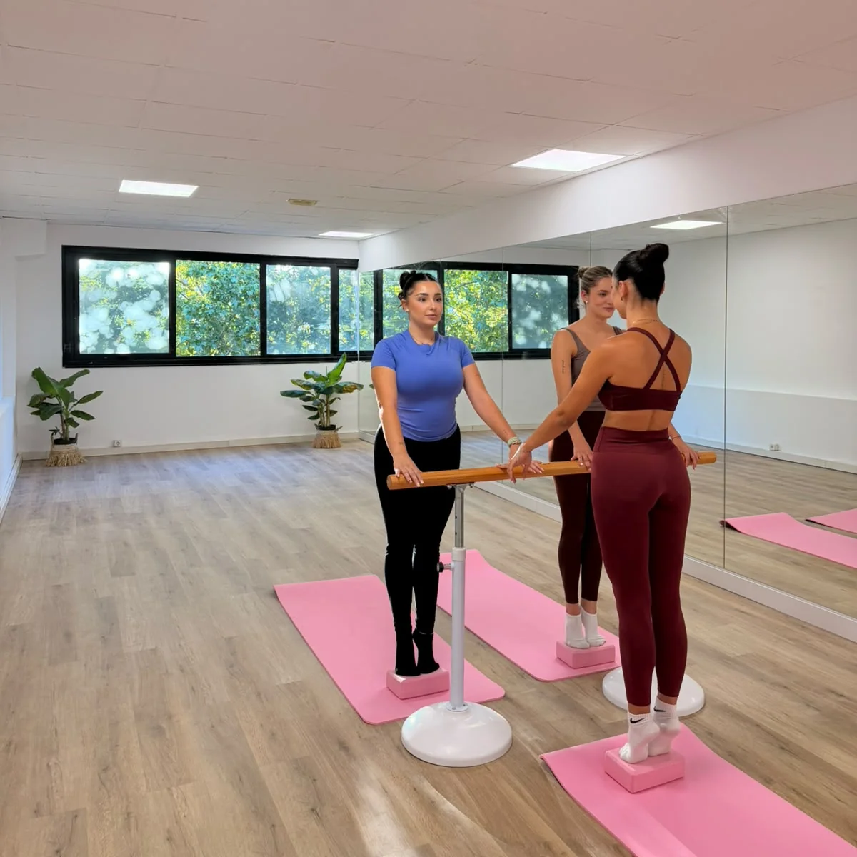 Dos alumnas practicando junto a la barra durante una clase de barre en Bodylab, San Sebastián de los Reyes