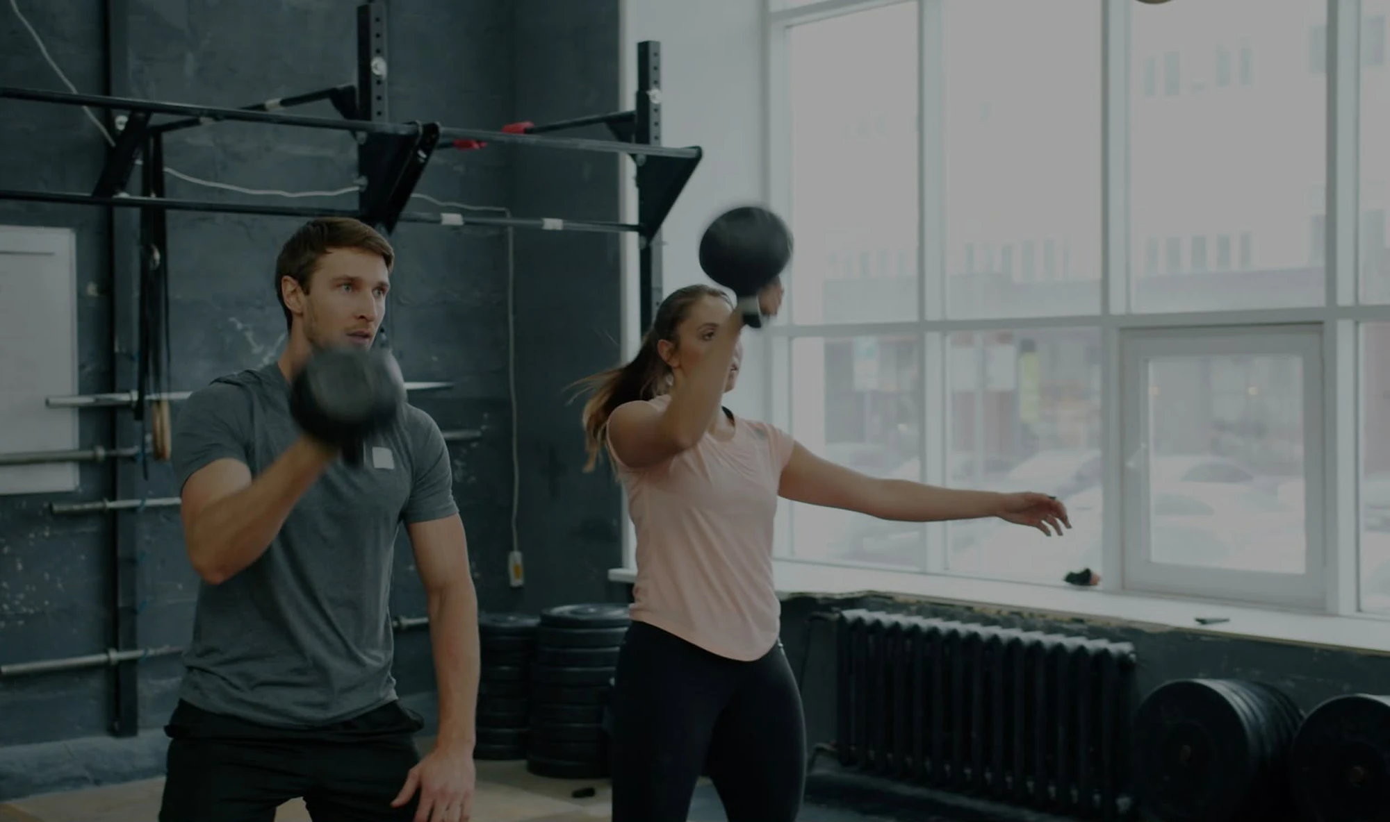 Dos alumnos realizando un ejercicio de fuerza funcional con peso durante un entrenamiento en Bodylab, San Sebastián de los Reyes