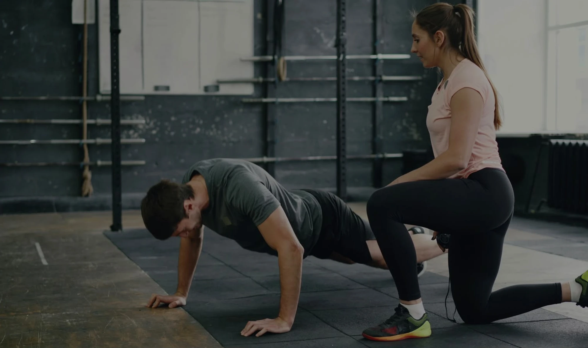 Entrenadora personal guiando a un alumno durante un ejercicio de fuerza funcional en Bodylab, San Sebastián de los Reyes