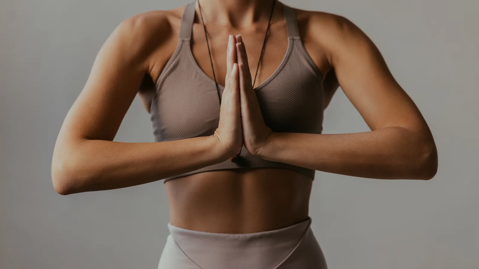 Alumna en una postura de yoga con las manos juntas