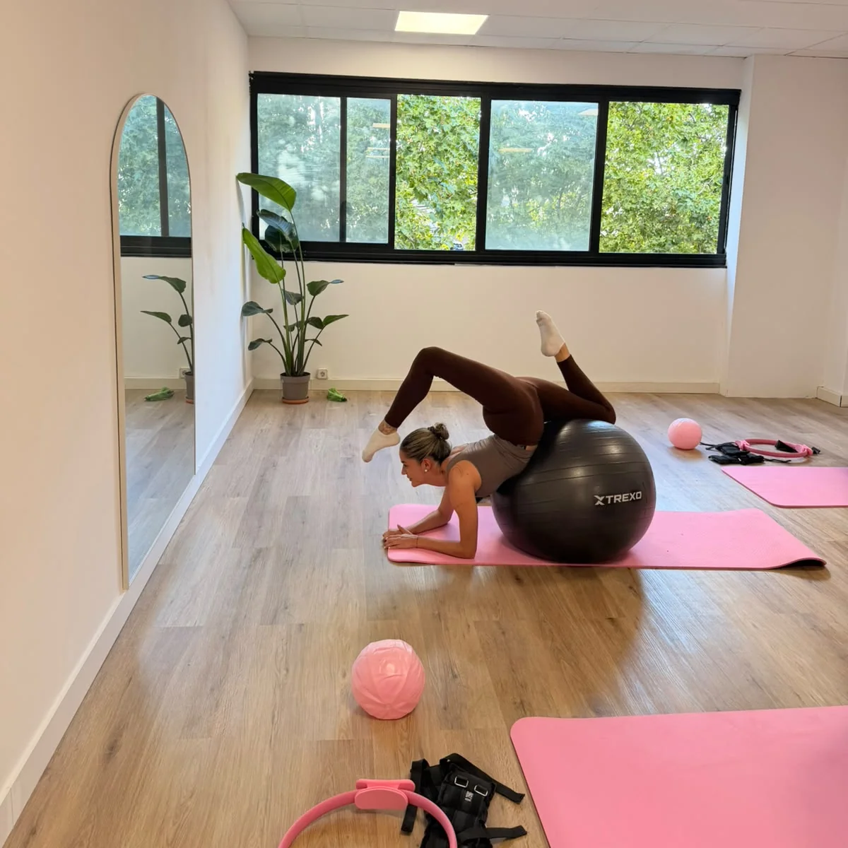 Alumna estirando con un fitball sobre una esterilla durante una clase de pilates sculpt en Bodylab, San Sebastián de los Reyes