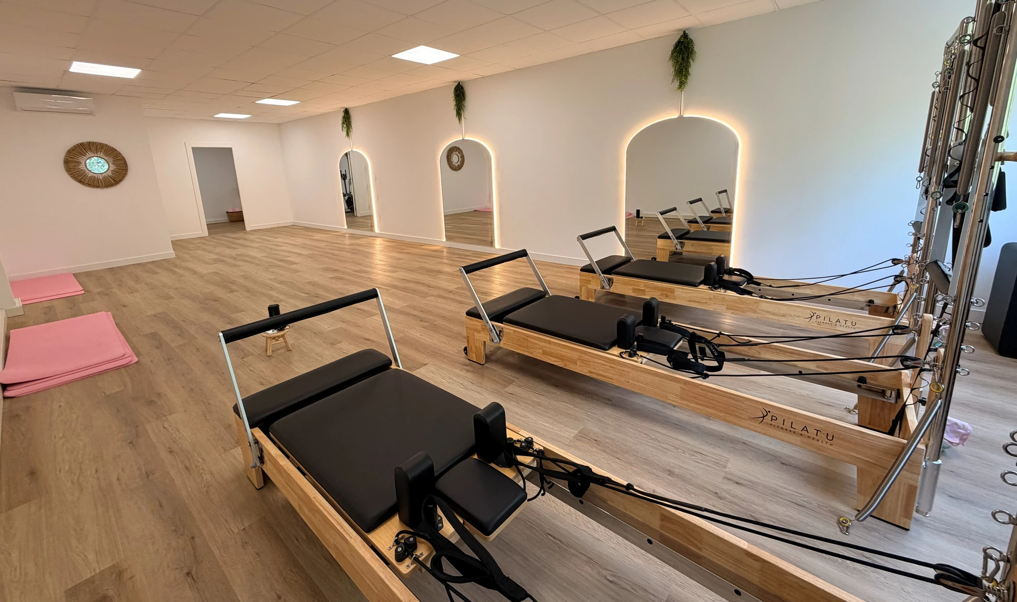 Sala de pilates reformer de Bodylab con varias máquinas reformer y espejos en arco, San Sebastián de los Reyes